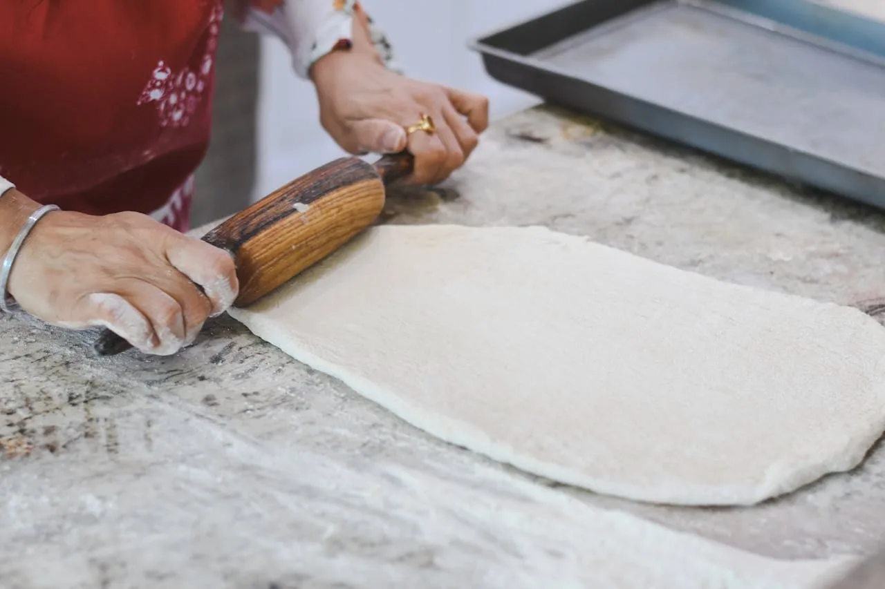 Pastelera amasando masa para hacer un pastel.